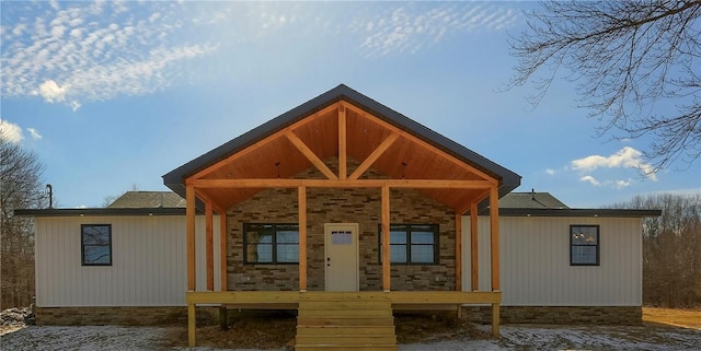 back of house featuring a porch and stone siding