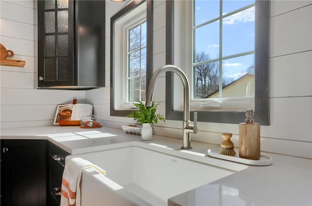 details featuring dark cabinetry, light countertops, and a sink