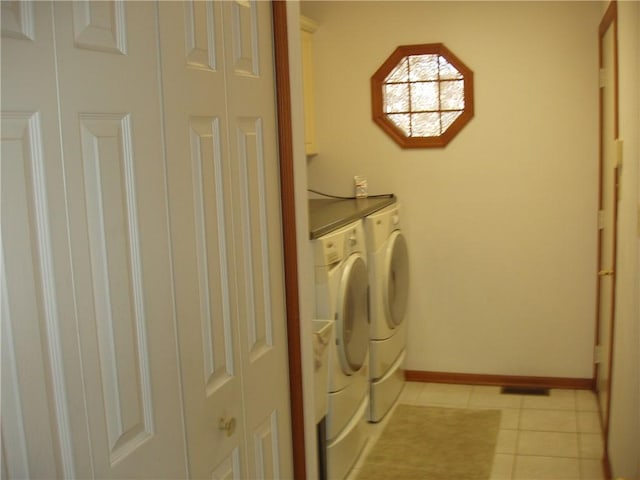 laundry room with cabinet space, independent washer and dryer, baseboards, and light tile patterned floors