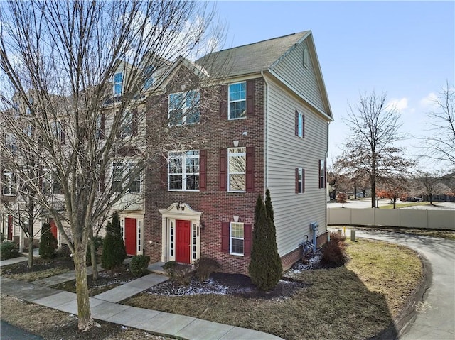 view of front of house with brick siding and fence