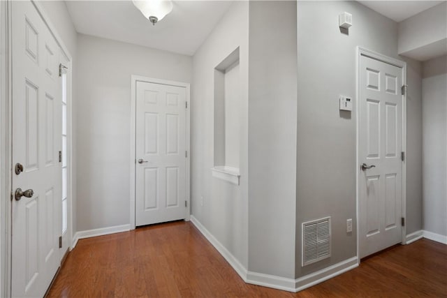 entrance foyer featuring baseboards, visible vents, and wood finished floors