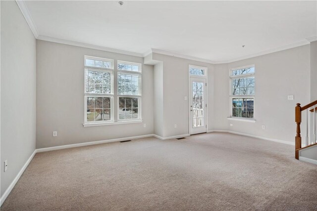 empty room with stairs, crown molding, light carpet, and baseboards