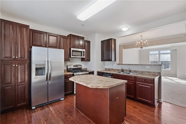 kitchen featuring dark wood-style flooring, a sink, light countertops, appliances with stainless steel finishes, and a center island