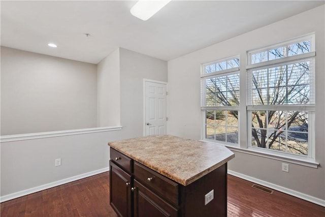 kitchen with light countertops, dark wood-style flooring, visible vents, and baseboards