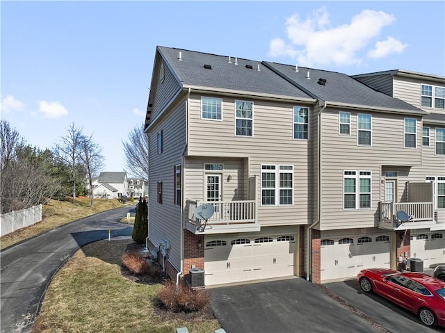 exterior space featuring a garage, cooling unit, and driveway