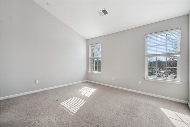 carpeted empty room featuring lofted ceiling, visible vents, and baseboards