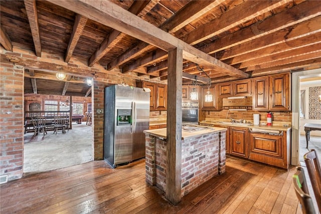 kitchen with dark wood finished floors, stainless steel appliances, light countertops, wooden ceiling, and beamed ceiling