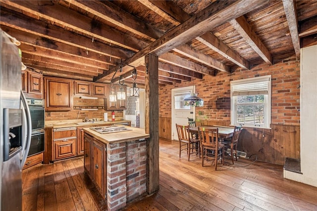 kitchen featuring brown cabinets, beam ceiling, wooden counters, and dark wood finished floors