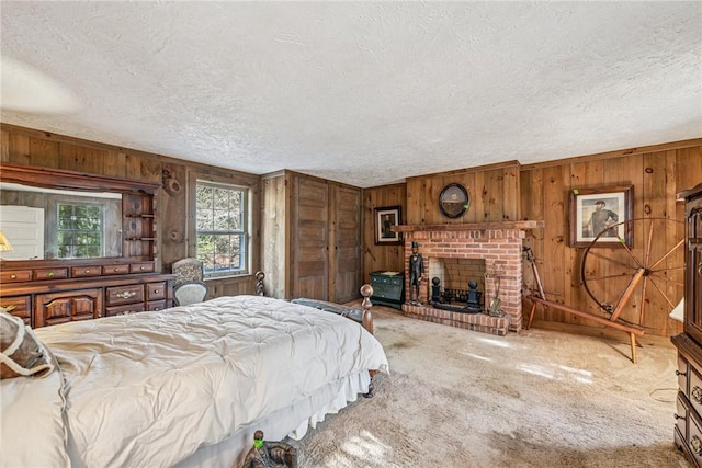 carpeted bedroom with a textured ceiling, wood walls, and a fireplace