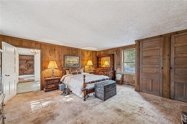 bedroom featuring a textured ceiling, carpet, and wooden walls