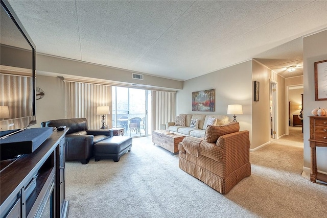 living area with baseboards, carpet, visible vents, and a textured ceiling