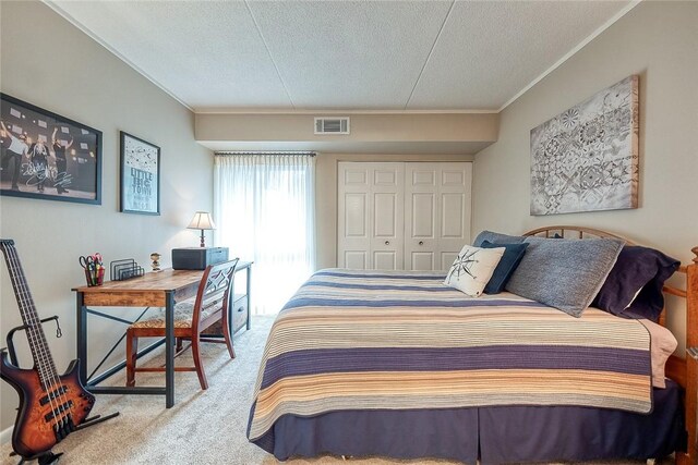 bedroom with carpet floors, a closet, visible vents, ornamental molding, and a textured ceiling