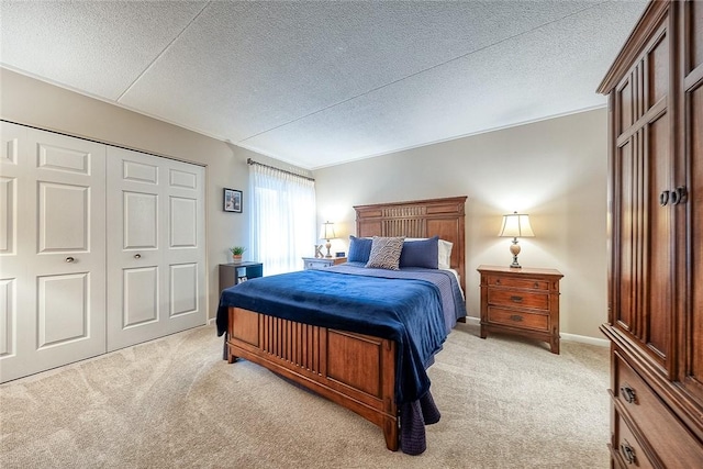 bedroom featuring a textured ceiling, baseboards, and light colored carpet