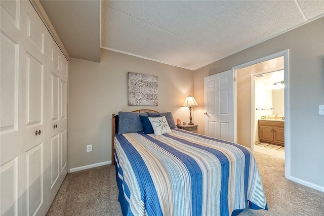 carpeted bedroom with a closet, baseboards, and a textured ceiling