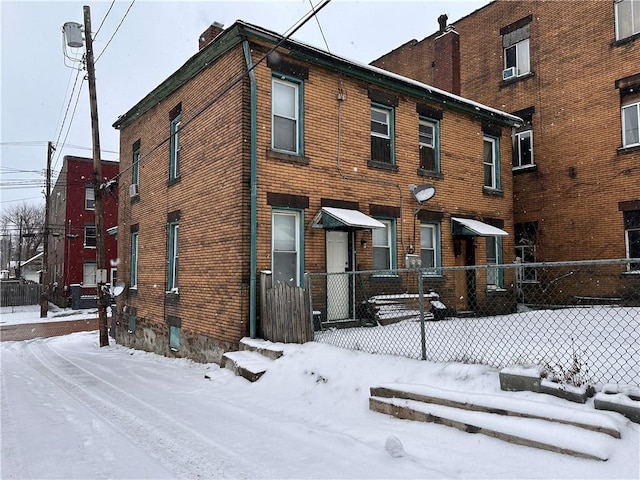 view of front of house featuring brick siding and fence