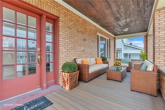 wooden deck featuring a porch and an outdoor hangout area