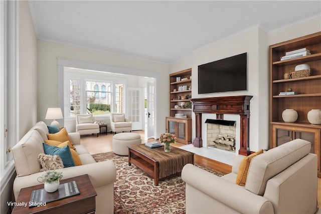 living room with crown molding, a fireplace with flush hearth, and built in features