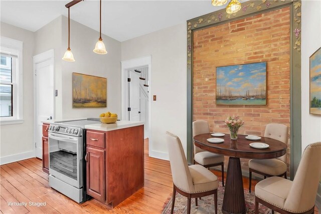 kitchen with electric stove, light wood finished floors, and baseboards