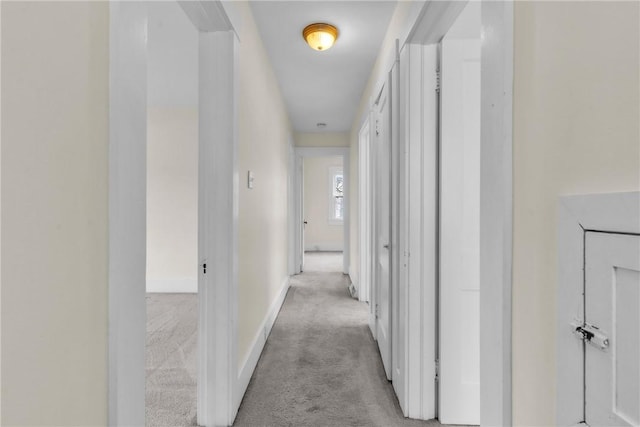 hall featuring carpet flooring and baseboards