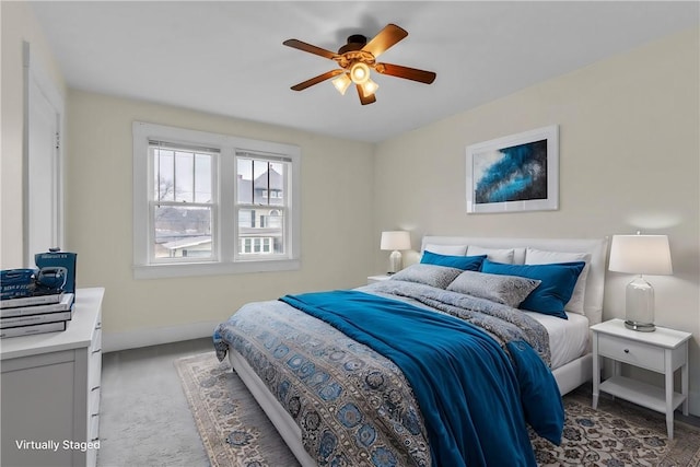 carpeted bedroom with a ceiling fan and baseboards