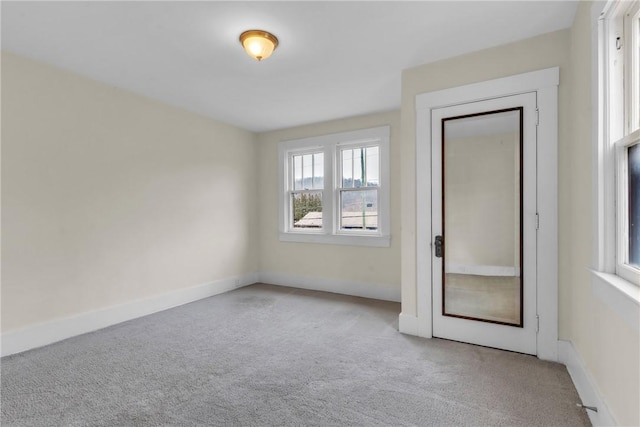 unfurnished room featuring carpet floors and baseboards