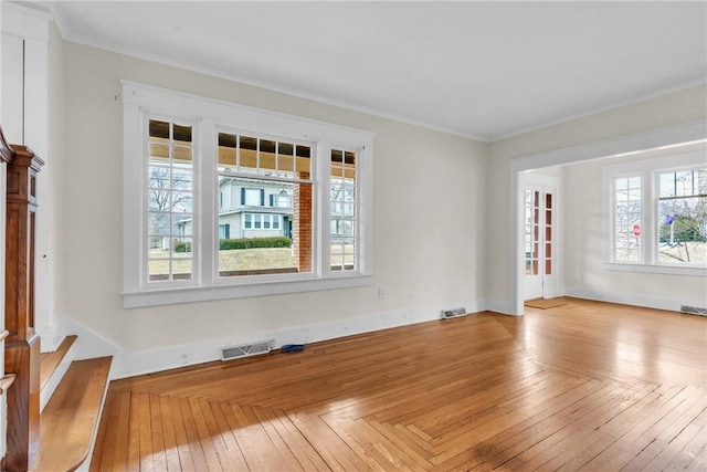 unfurnished room featuring visible vents, crown molding, baseboards, and hardwood / wood-style flooring