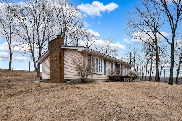 view of home's exterior with a chimney and a deck