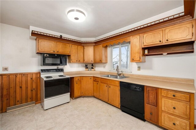 kitchen with light countertops, visible vents, wainscoting, a sink, and black appliances