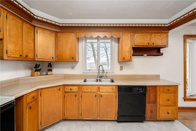 kitchen featuring brown cabinetry, black dishwasher, light countertops, and a sink