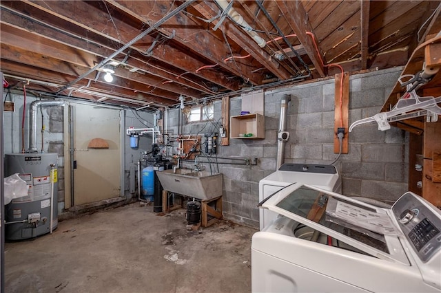 basement with water heater, a sink, and separate washer and dryer