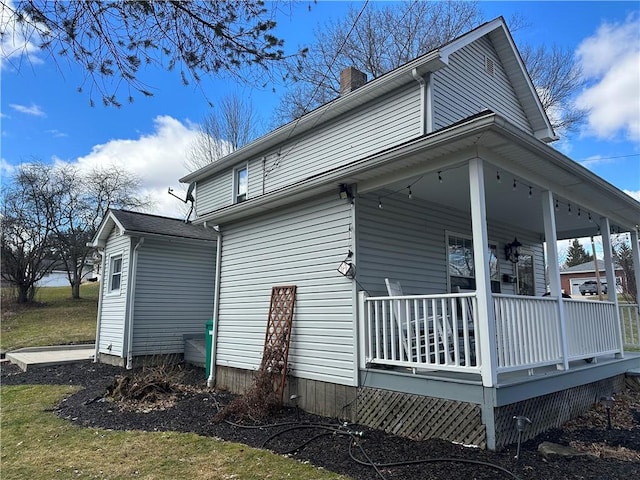 view of property exterior featuring covered porch and a chimney