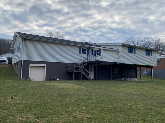 rear view of property with a garage, stairway, a deck, and a lawn