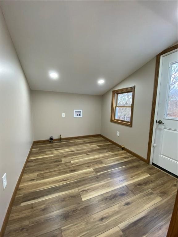 interior space featuring vaulted ceiling, wood finished floors, and baseboards