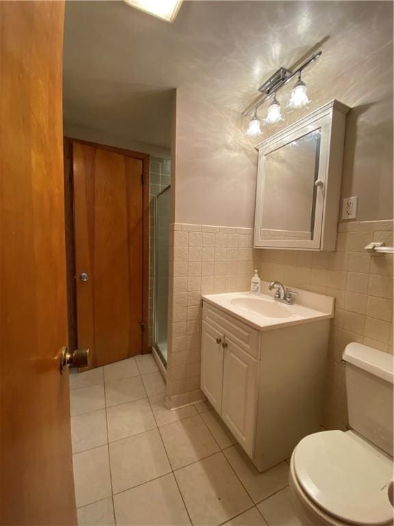 bathroom with tile patterned flooring, a shower stall, tile walls, and toilet