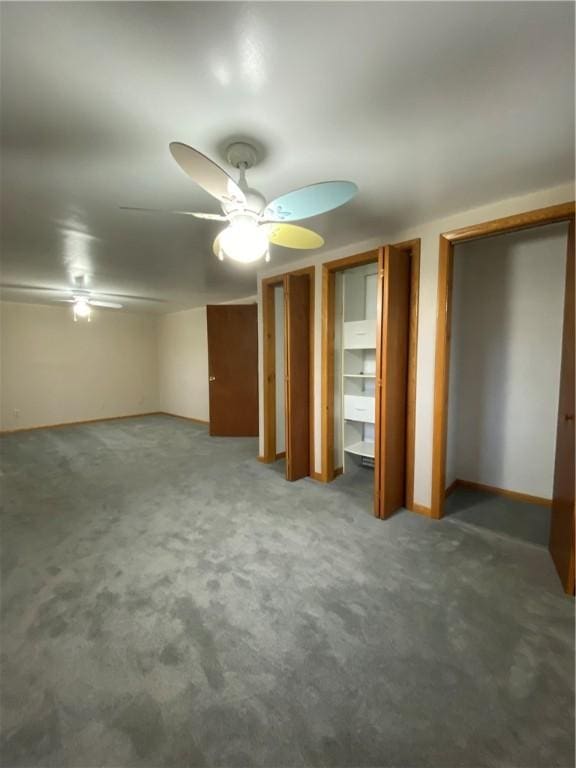 unfurnished bedroom with carpet, a ceiling fan, and multiple closets