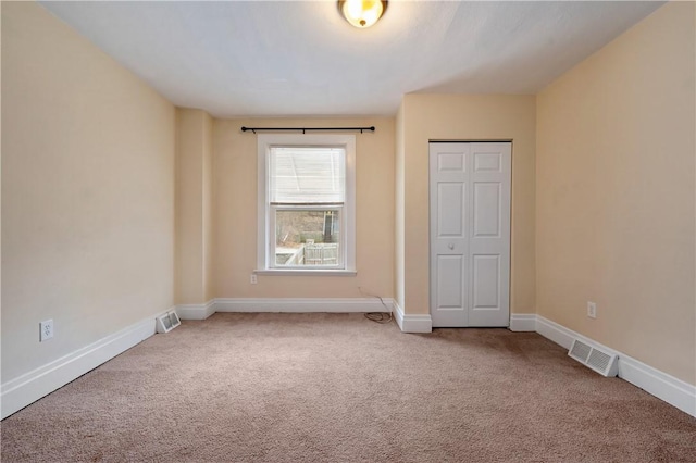 unfurnished bedroom featuring a closet, carpet flooring, visible vents, and baseboards