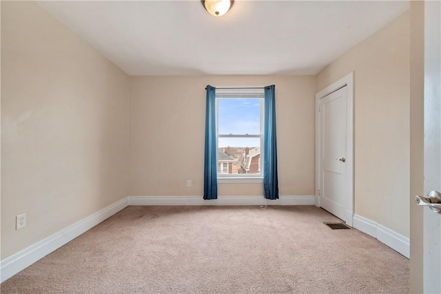 carpeted empty room featuring baseboards