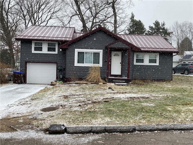 view of front of house with a garage, driveway, and metal roof