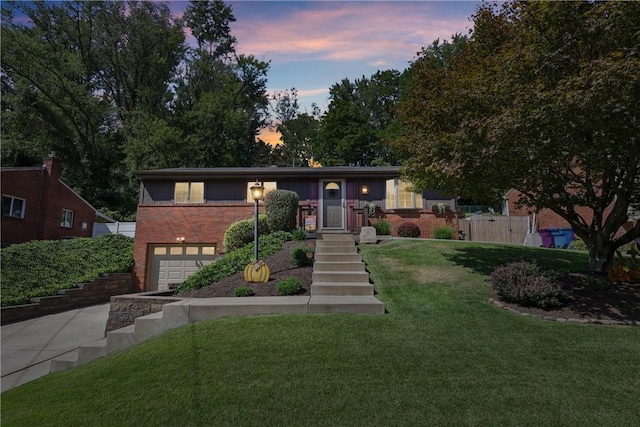 view of front facade featuring a garage, a front yard, concrete driveway, and brick siding