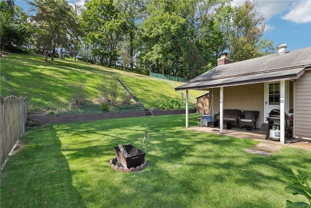 view of yard featuring fence, a fire pit, and a patio