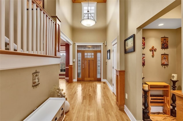 entrance foyer featuring a high ceiling, baseboards, and wood finished floors