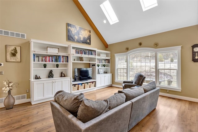 living room with a skylight, light wood-style flooring, visible vents, and high vaulted ceiling