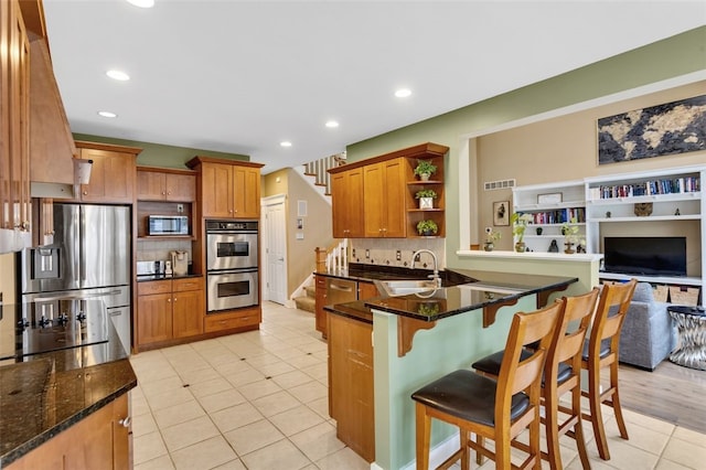 kitchen featuring light tile patterned floors, stainless steel appliances, open shelves, backsplash, and a peninsula