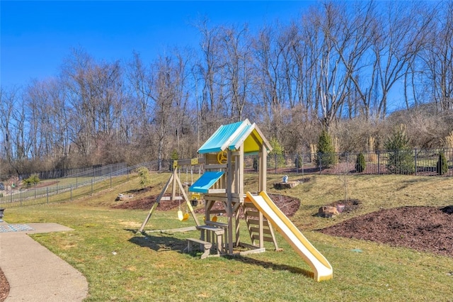 view of playground featuring a lawn and fence