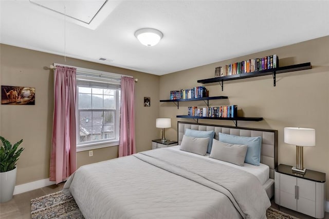 bedroom with attic access, visible vents, and baseboards