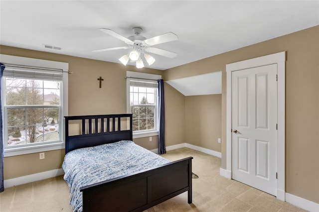 bedroom featuring baseboards, visible vents, light colored carpet, lofted ceiling, and ceiling fan