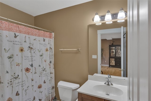 bathroom featuring toilet, curtained shower, and vanity