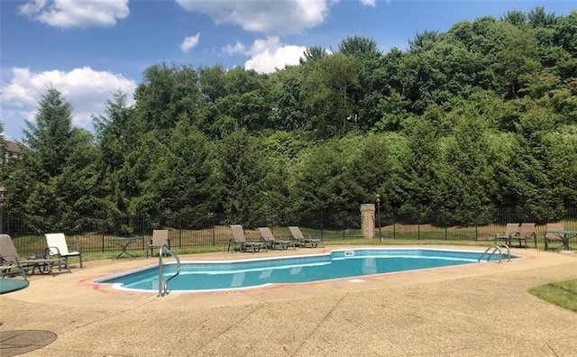 community pool with fence and a patio