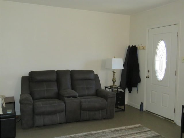 living area with baseboards and concrete flooring