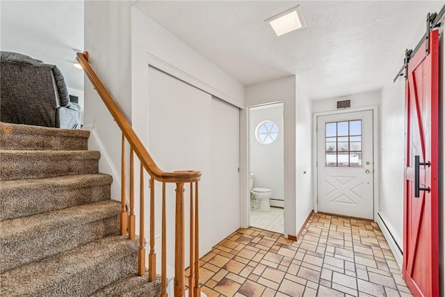 foyer with stairs, a barn door, baseboard heating, and a baseboard radiator